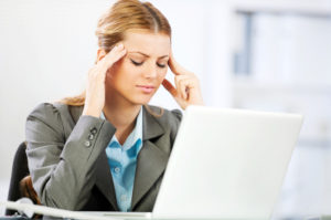 Businesswomen stressed holding her hands to her forehead. Tired businesswoman.